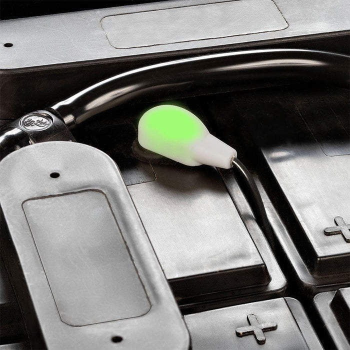 Battery watering monitor with glowing green indicator on industrial battery cell