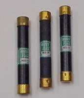 Three cylindrical power fuses with black bodies and brass ends for electrical applications